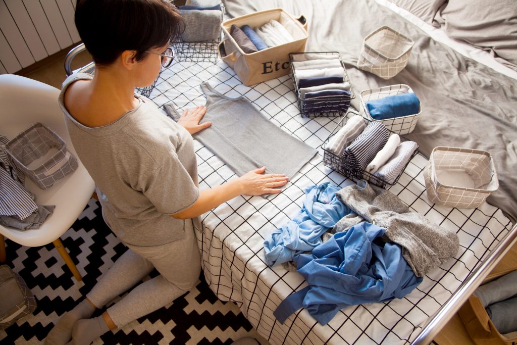 Woman folding clothes using Marie Kondo Tips