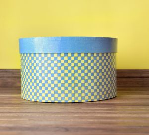 decorative hat box blue and yellow on a wooden floor