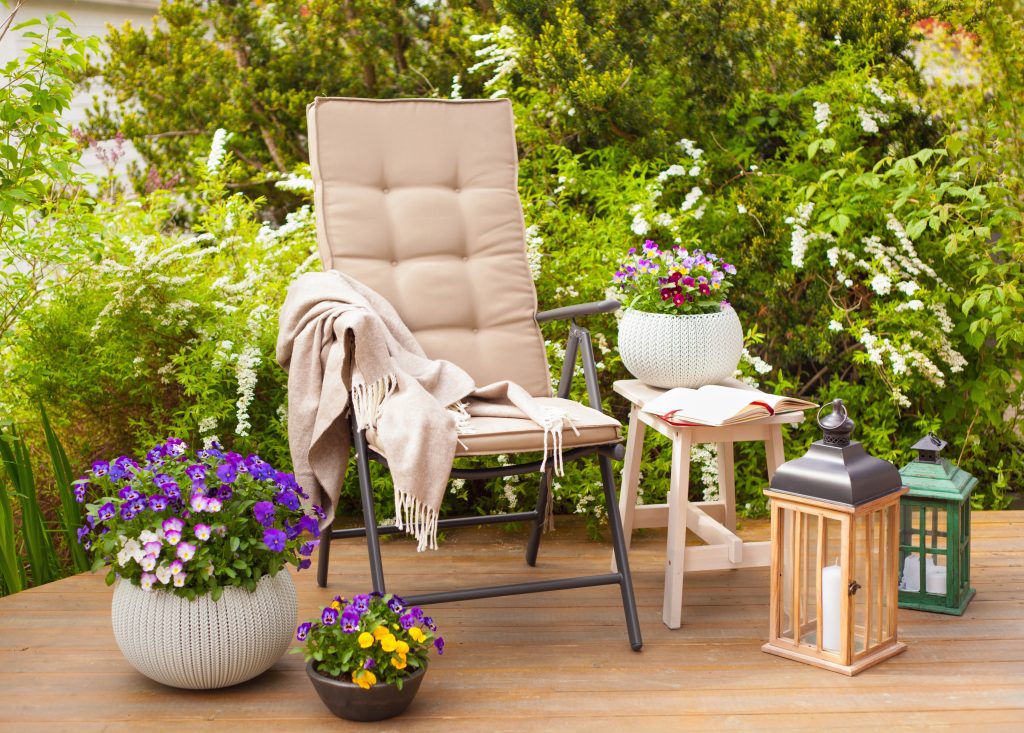 garden chair and table on terrace flowers  bush