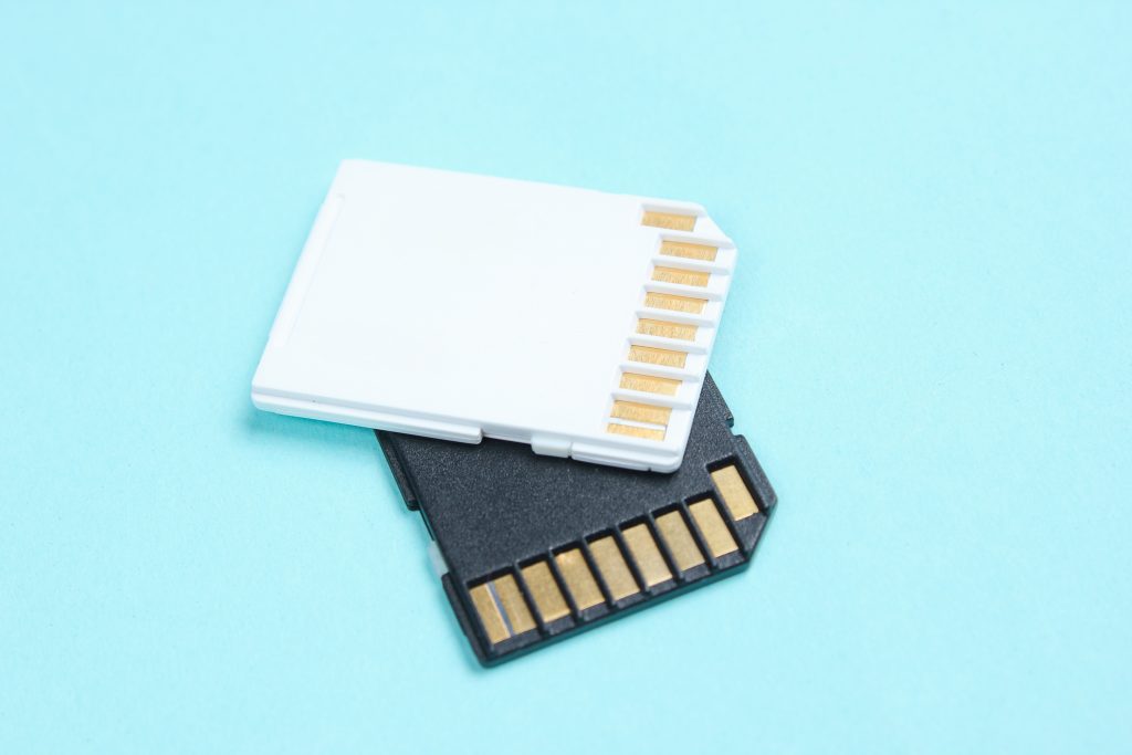 Two Mini SD memory cards on blue background close up