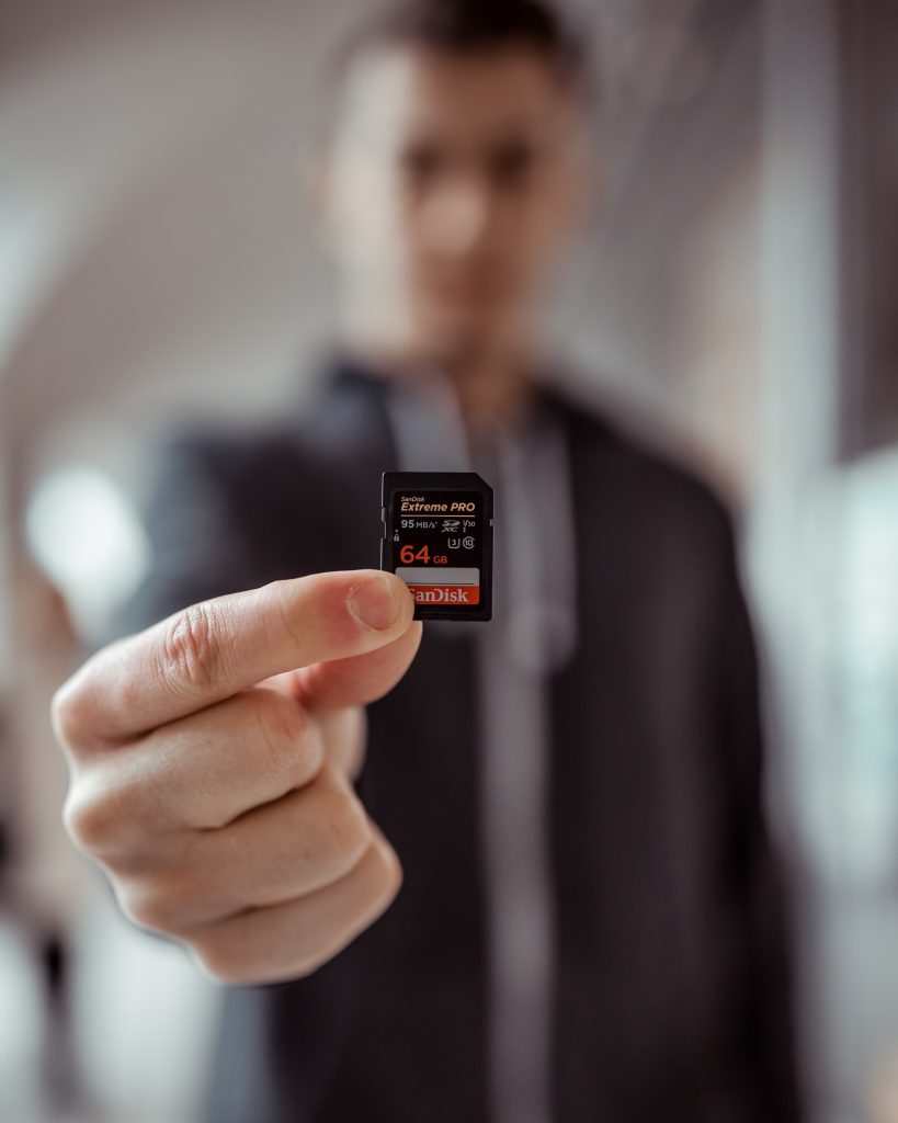 Person Holding Sandisk 64gb MicroSD Adapter