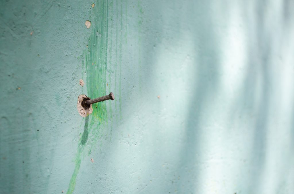 A nail on a green wall