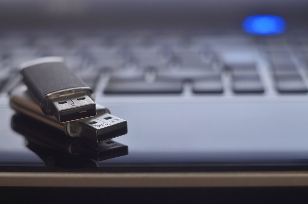 USB flash cards lying on black laptop 