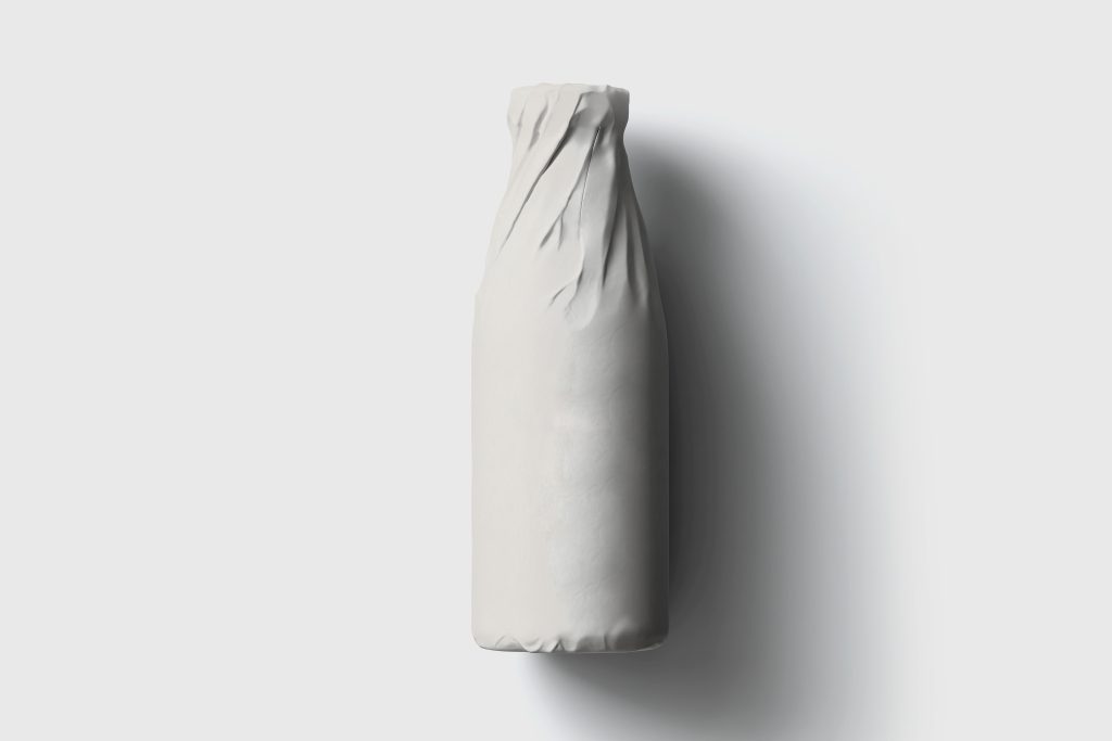 Bottle wrapped in white paper on white background.Mockup.High resolution photo.
