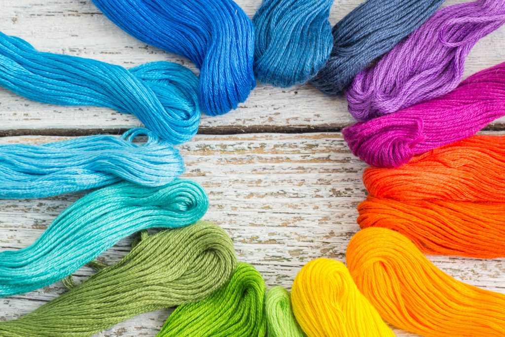 colorful sewing threads for embroidery on white background