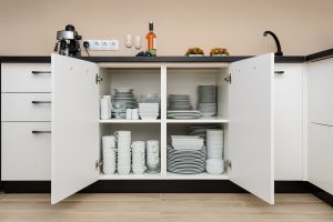 Dishware storage cabinet with plates and cups inside