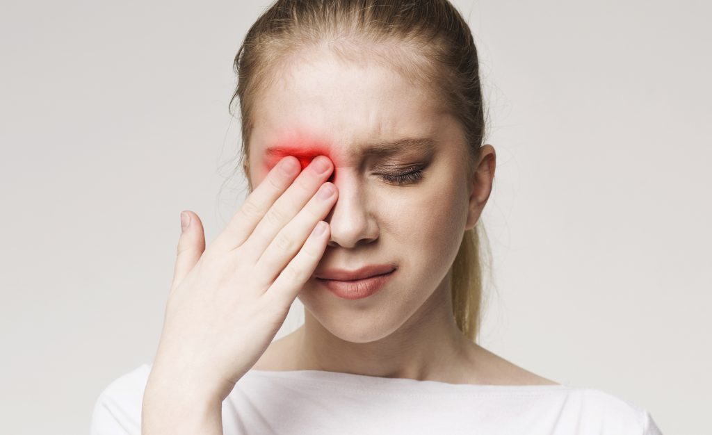 Upset woman suffering from strong eye pain