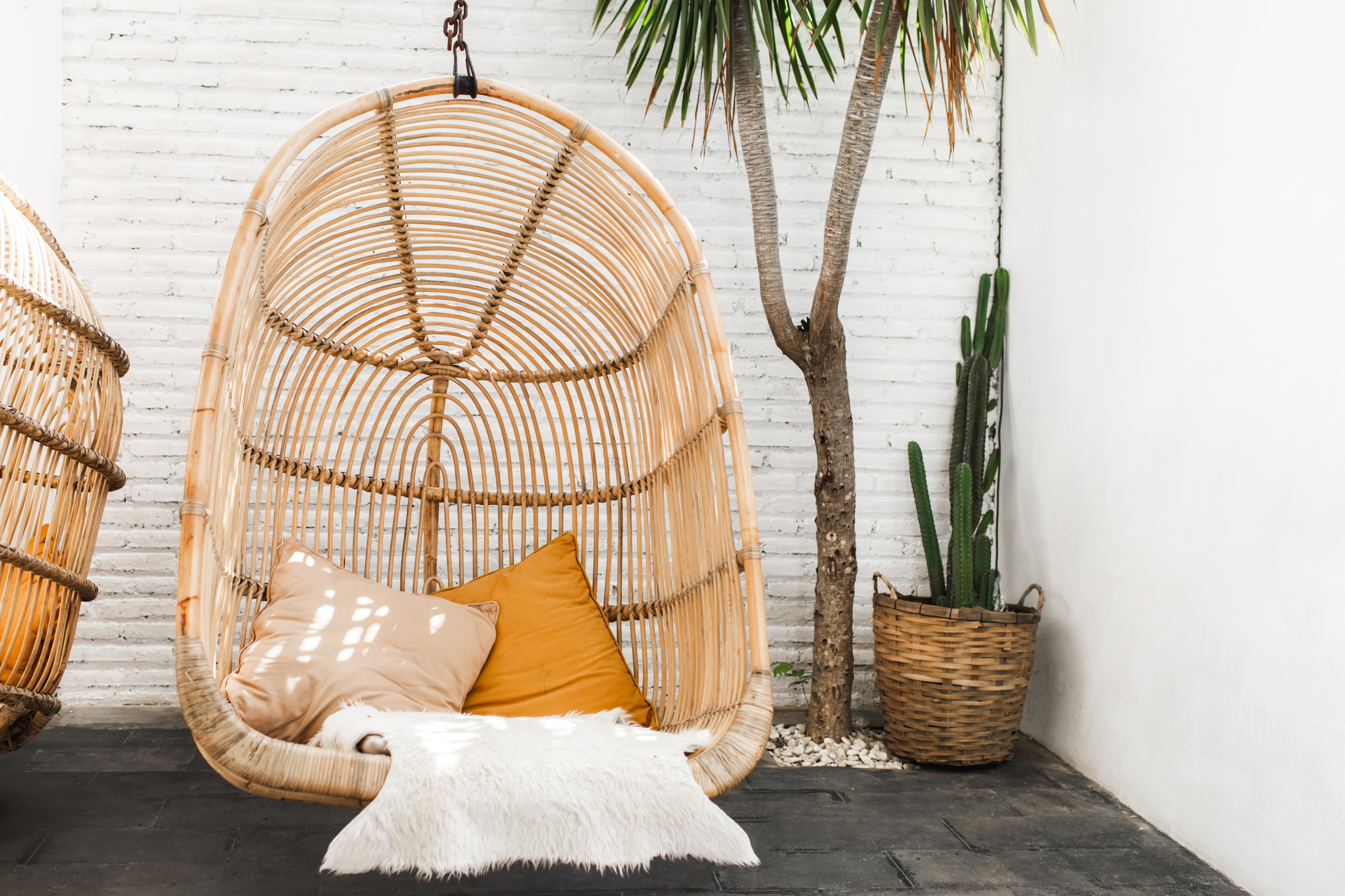 https://storables.com/wp-content/uploads/2021/06/Wicker-rattan-hanging-chair-in-loft-cafe.-Eco-friendly-furniture-style-and-concept.-Orange-pillows-and-soft-fur-on-chair..jpeg